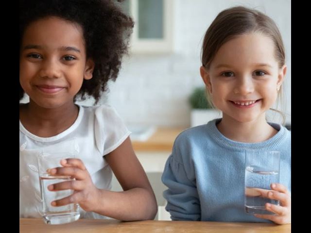 Two kids with glasses of drinking water tested with at-home testing kits from 鶹ɫ 